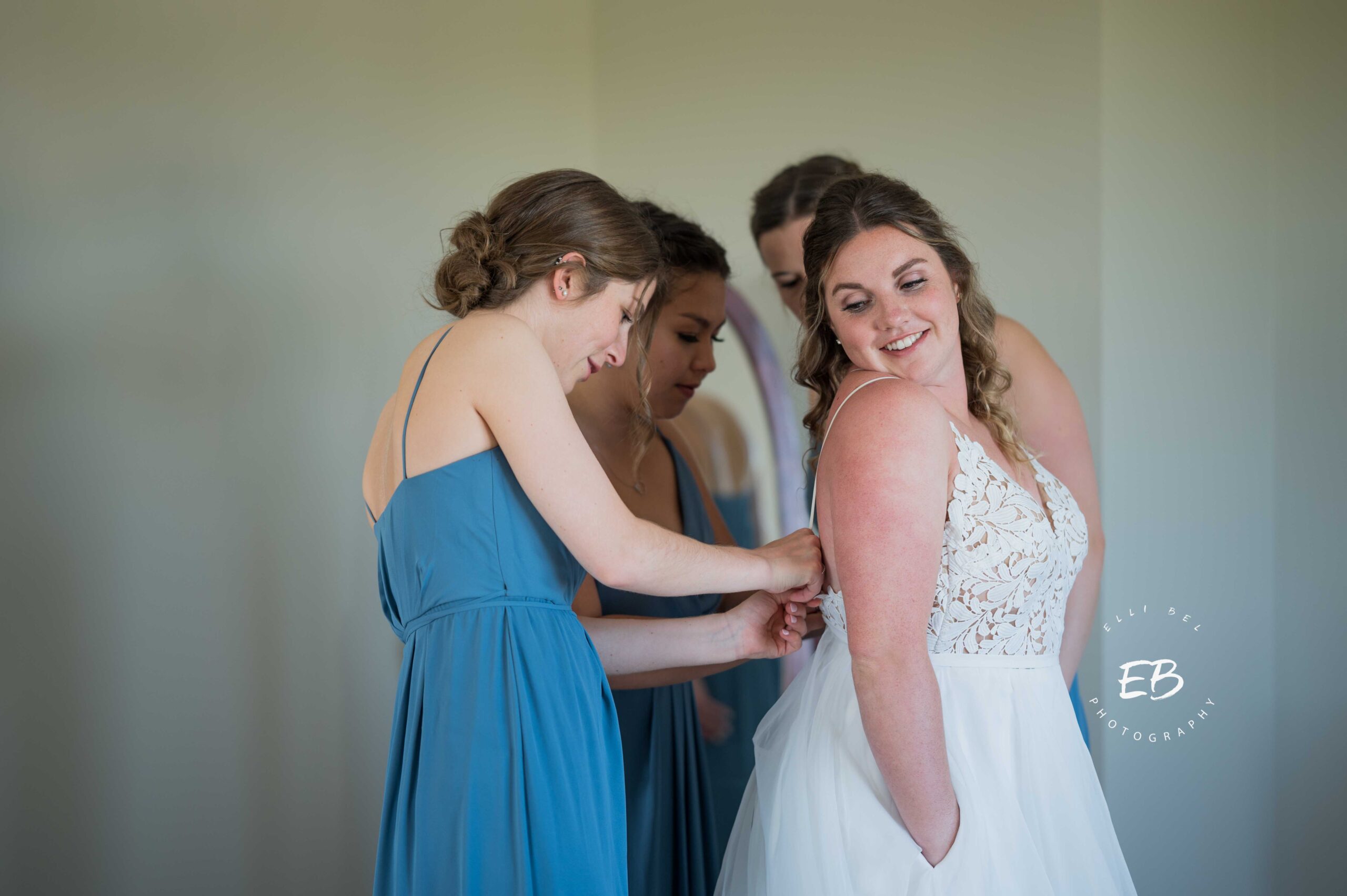 bridesmaids helping bride with dress