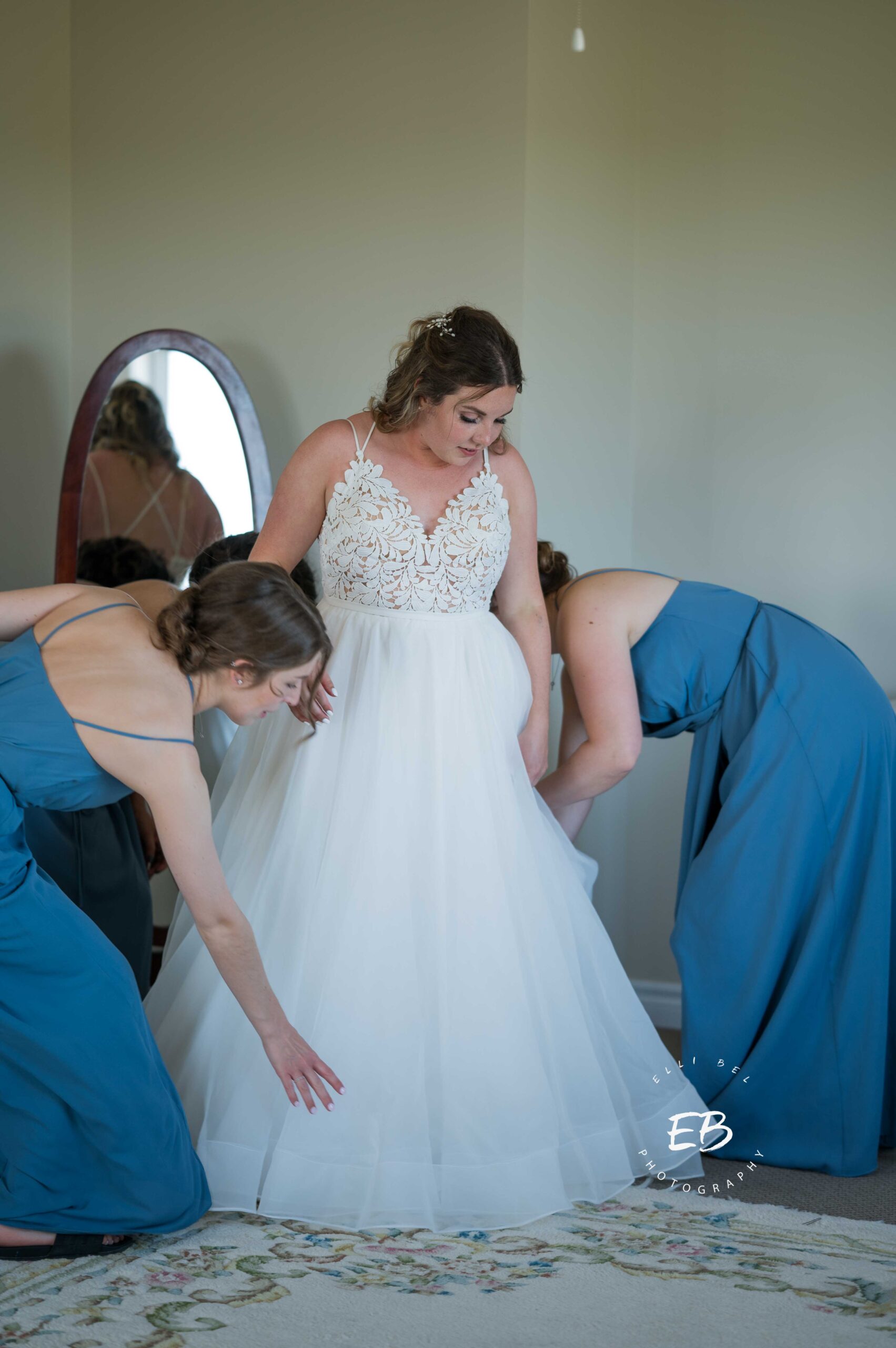 bridesmaids helping bride with dress